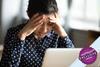 Lady sitting in front of laptop with her head in her hands