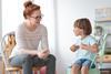 Woman taking to a child sat on a sofa