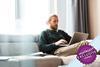 Man sat on sofa typing on a laptop