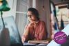 Woman sat down watching something on her laptop