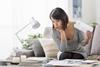 Woman sat on sofa going through paperwork