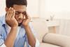 Man sat on sofa rubbing his temples