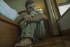 Man looking scared sat on bedroom floor
