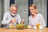 Middle aged couple eating health lunch together