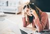 Woman sat at her desk on the phone looking stressed