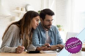 Couple sat at a table looking at a laptop making notes