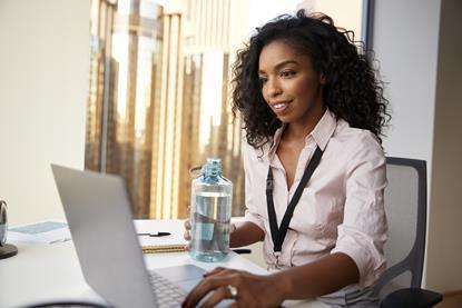 Woman sat at work desk with a bottle of water