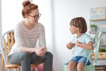 Woman taking to a child sat on a sofa