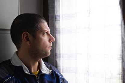 Man staring out a window looking pensive