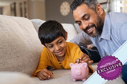 Father and son playing with piggy bank on sofa