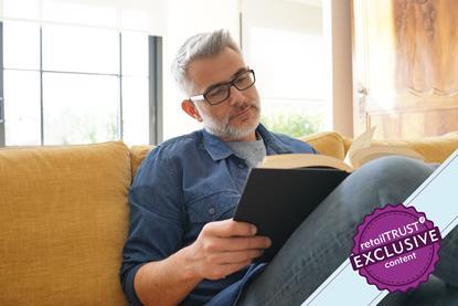 Man sat on sofa reading a book