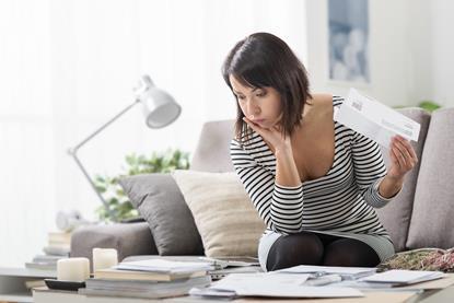 Woman sat on sofa going through paperwork