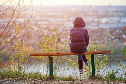 Rear view image of person sitting on a park bench