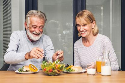 Middle aged couple eating health lunch together