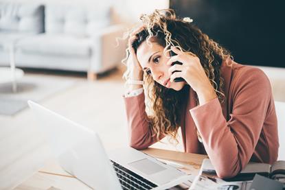 Woman sat at her desk on the phone looking stressed