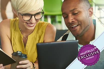 Man and woman looking at a tablet smiling