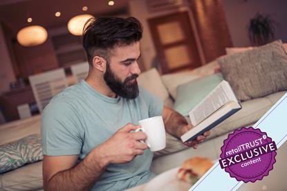 Man reading his book on sofa.  RT exclusive content badge